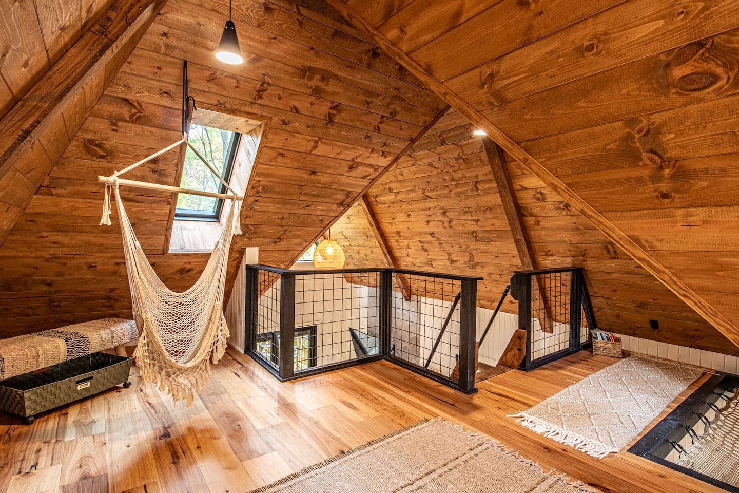 Adding a playful touch, a hammock is ingeniously built into the floor, perfect for lounging and soaking in the serene atmosphere. Nearby, a macrame swing hangs, providing a cozy nook to relax and sway gently while enjoying the tranquil forest view.