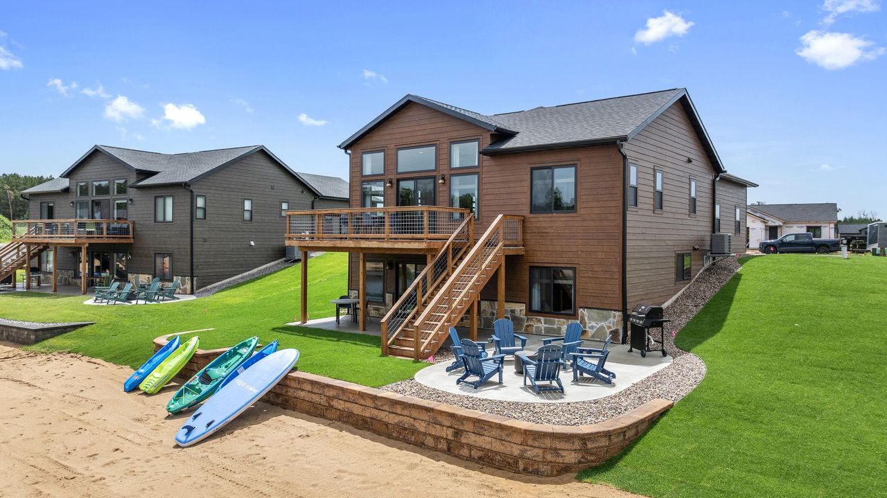 Camp & Lounge backyard area with kayaks, paddle boards, grills and fire pits