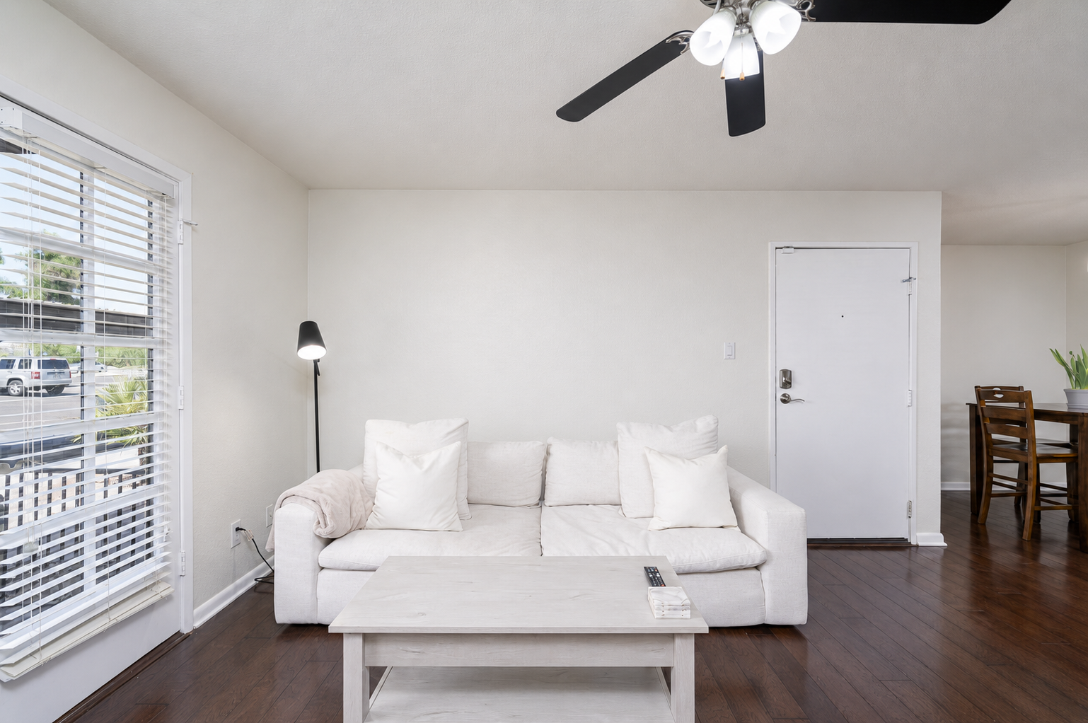 Open in-unit living area with sofa seating, Smart TV, ceiling fan, and easy flow to the dining space