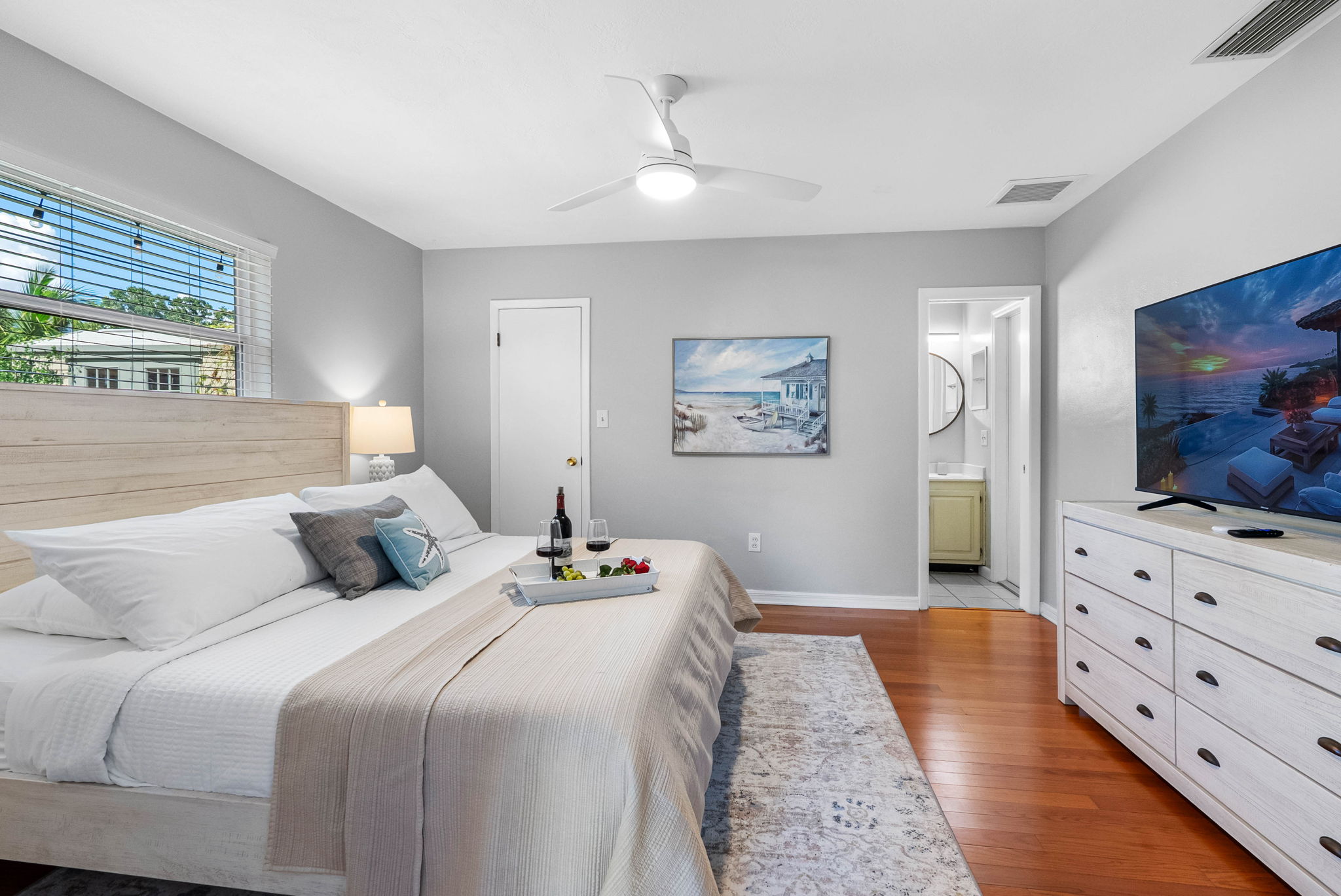A tranquil haven featuring a stylish wood bed frame, fresh linens, and calming sea-inspired decor.