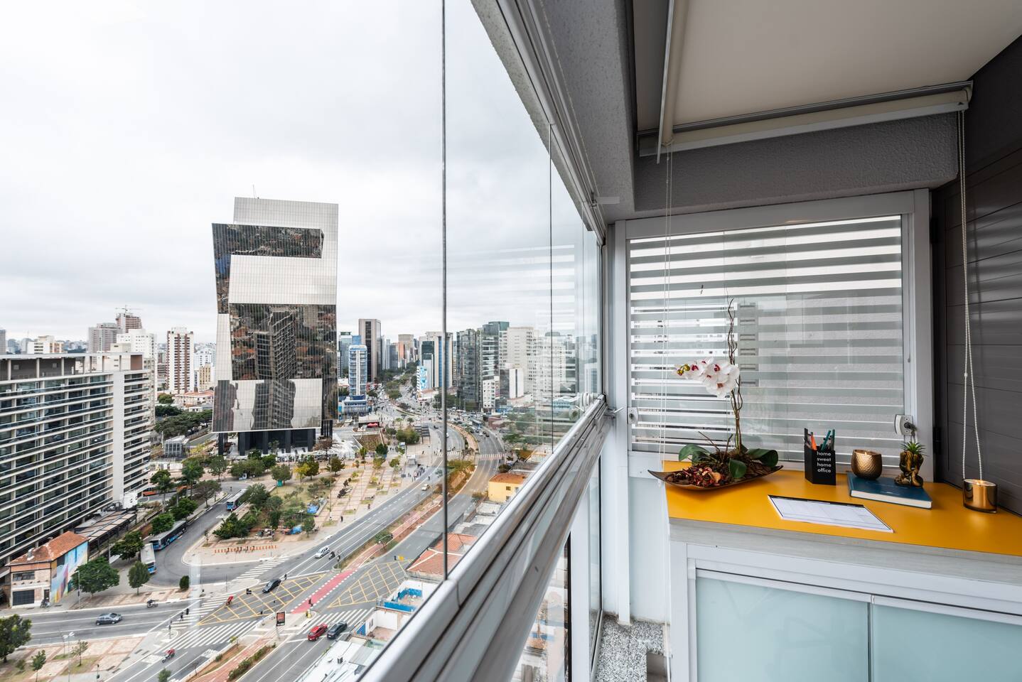 Varanda com espaço de trabalho exclusivo e vista para a Avenida Faria Lima, perfeito para home office em São Paulo.