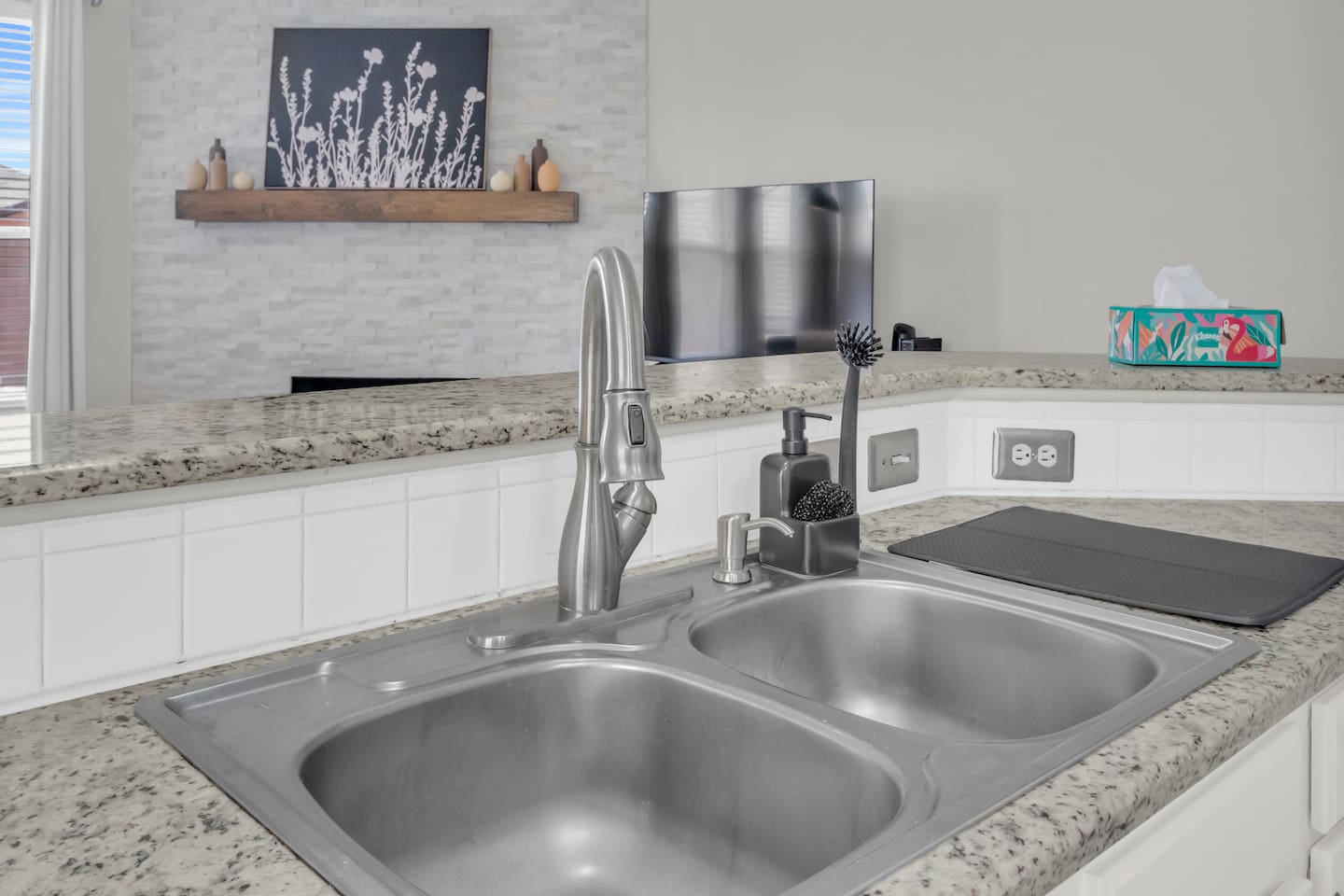 Functional kitchen setup with a double-basin sink, dishwasher nearby, and cooking essentials for effortless cleanup.