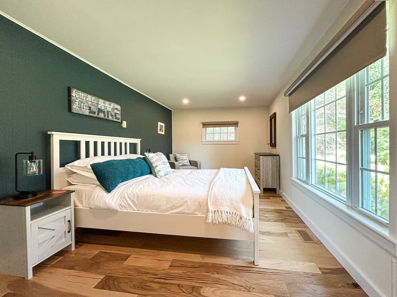 The queen bedroom is located on the ground floor, off of the great room, and has a view of the backyard and the lake in the distance