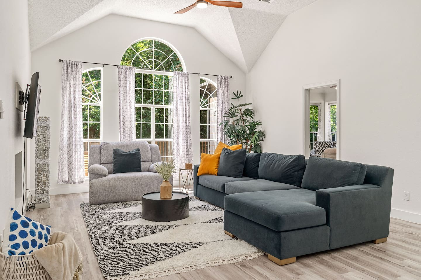 Modern open-concept living area with a TV that includes all major streaming services,  plush seating and natural light.