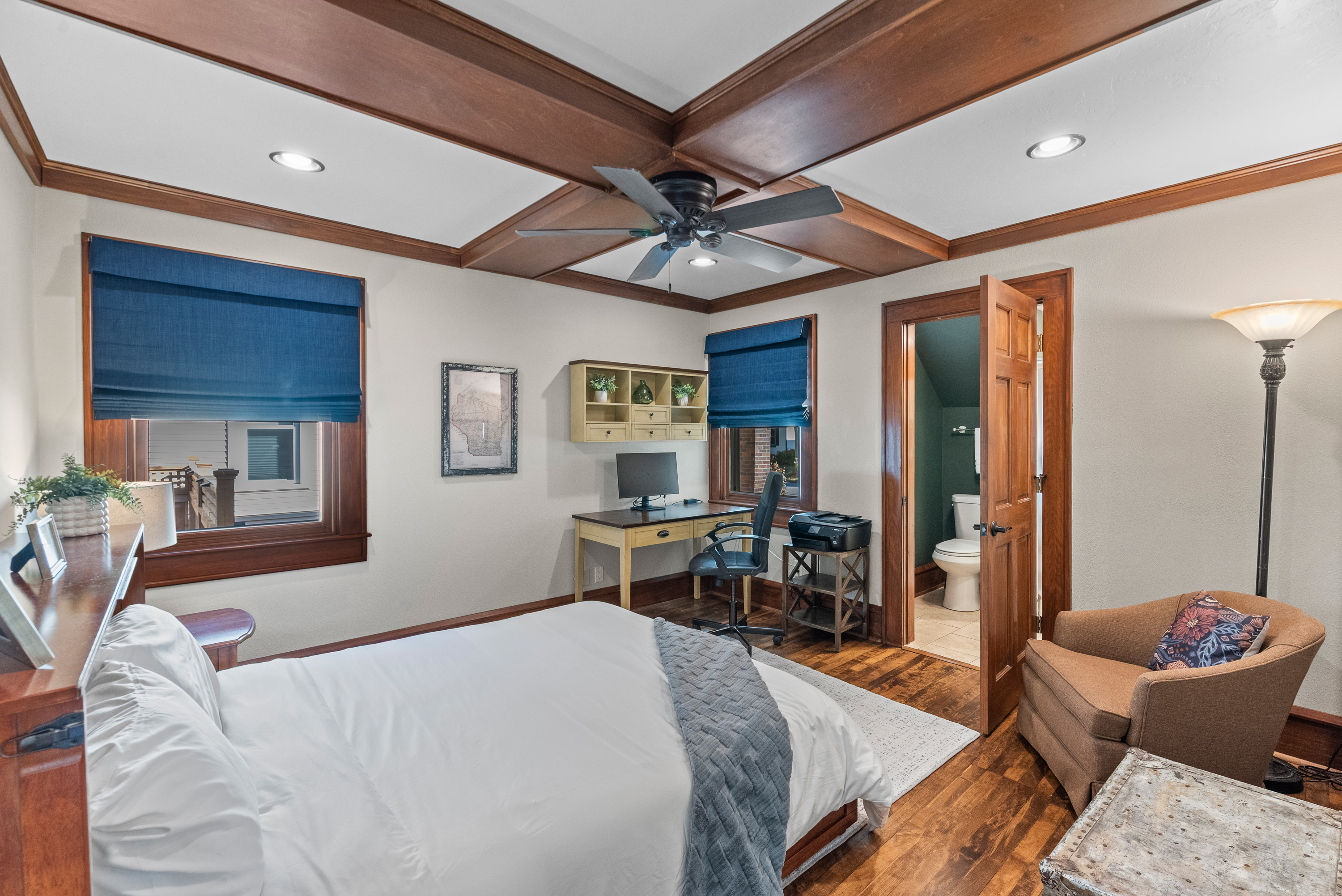 Main floor bedroom featuring a queen bed and designated work space.