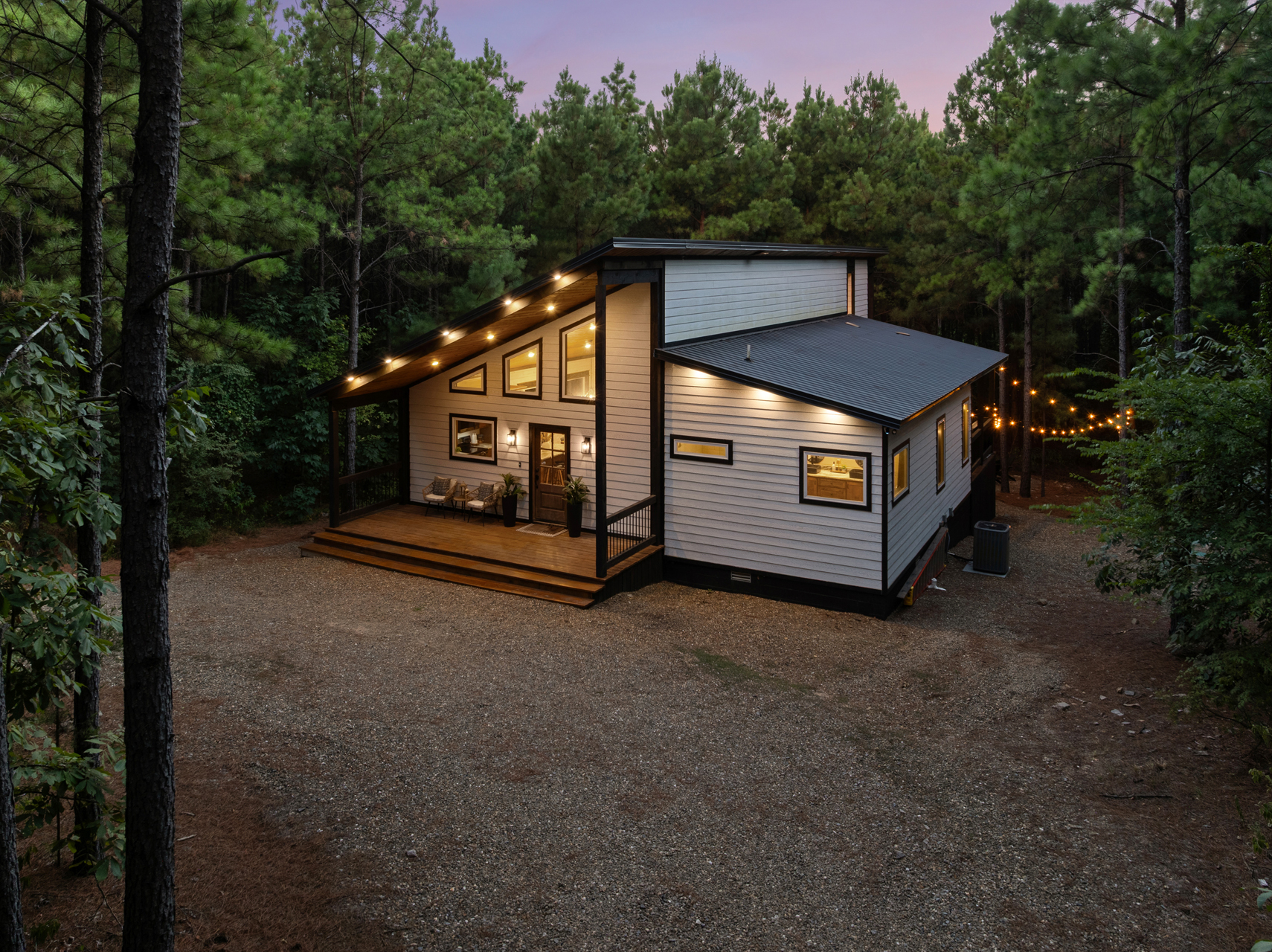 As evening settles in, the cabin lights up against the pines and turns into your own cozy hideaway in the woods.