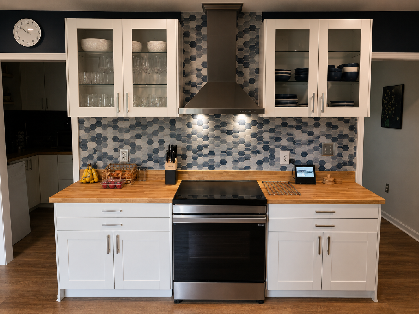 Kitchen cooking area with butcher block counters, full-size range, microwave and colorful tile backsplash.