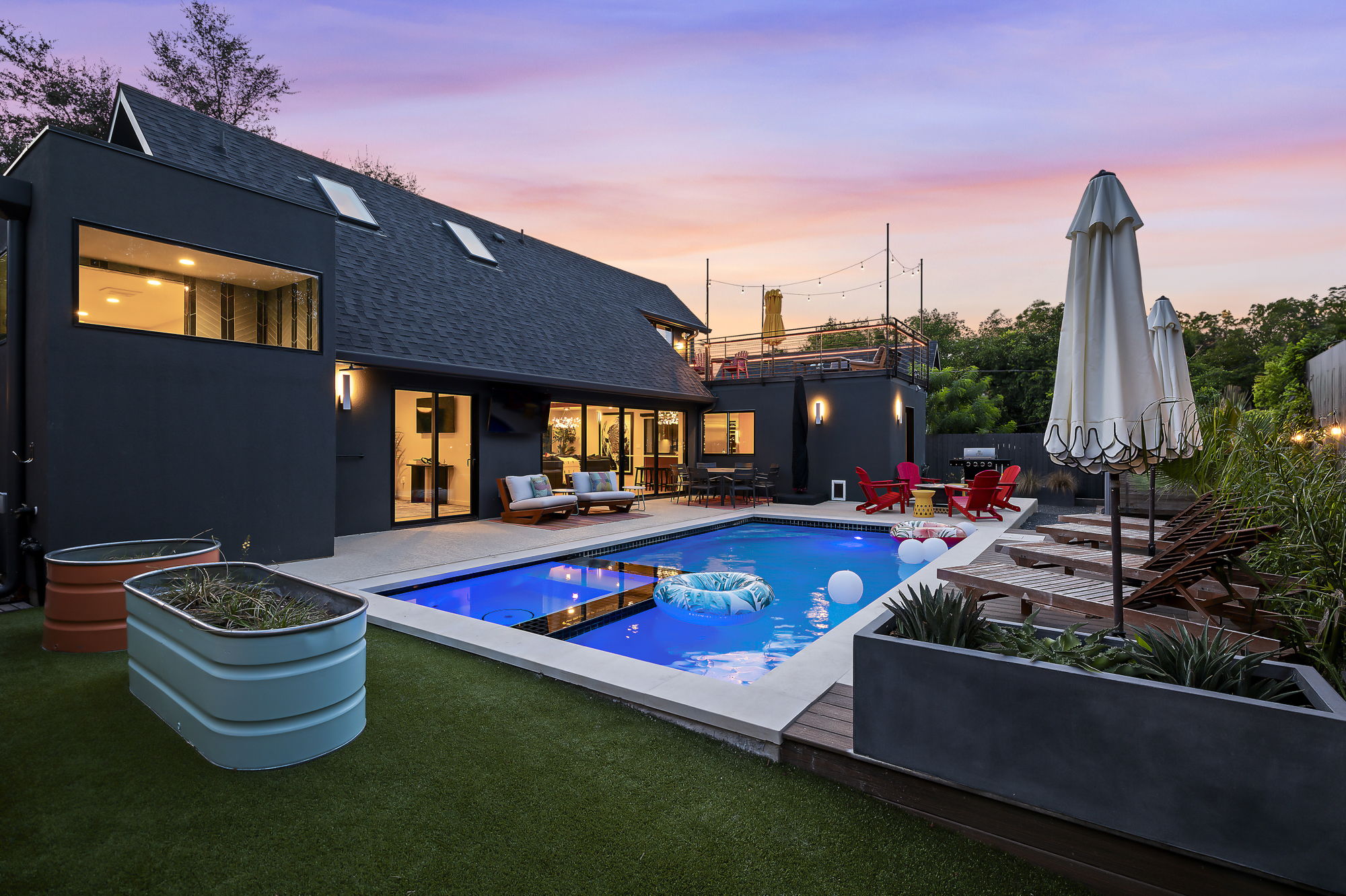 . This stunning backyard is an entertainer's dream, centered around a sparkling, illuminated pool that creates a resort-like atmosphere.