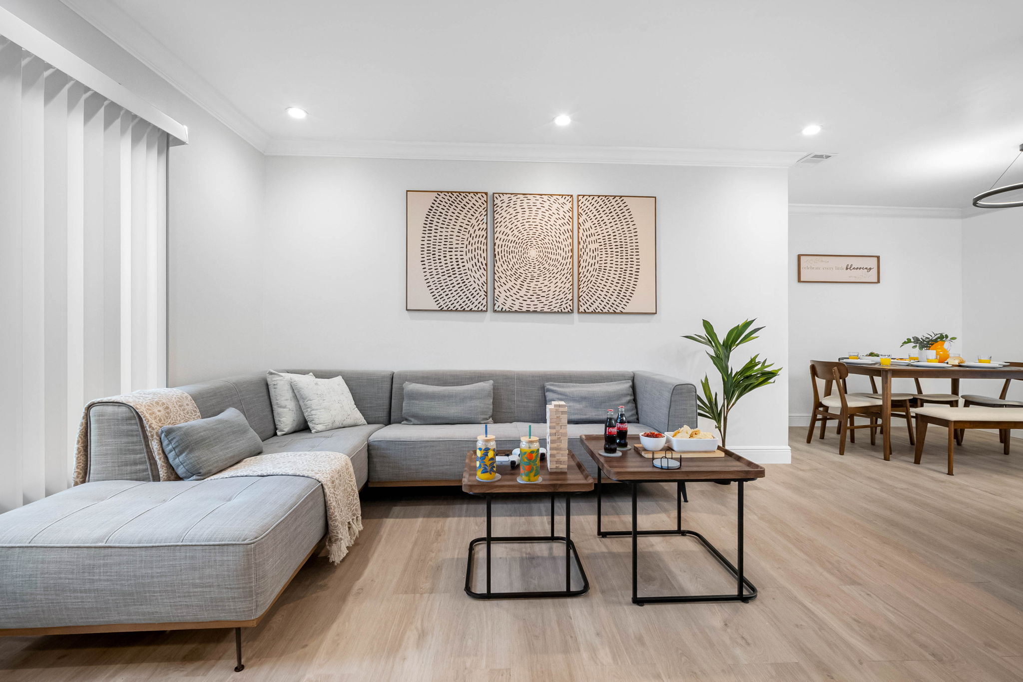 Perfect for movie nights or catching up with friends, this airy living room features wood floors, modern artwork, and a cozy vibe.