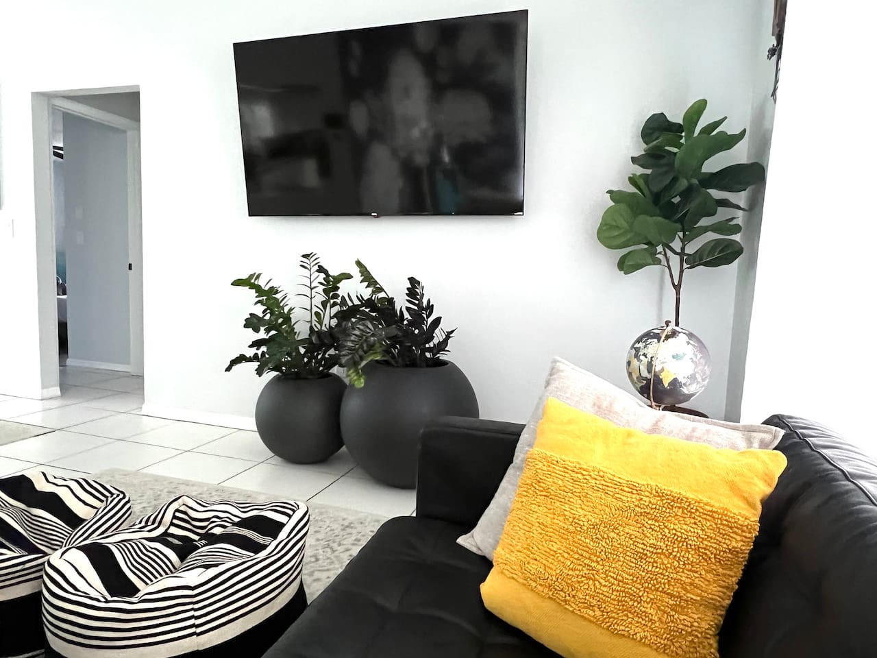 Step into this modern living room, featuring sleek, minimalist design with clean lines and neutral tones. A 70-inch smart TV takes center stage, perfect for movie nights or catching up on your favorite shows