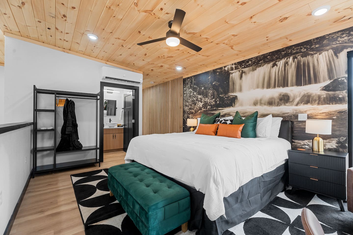 Lofted Bedroom Retreat: Relax in style with rich decor, natural light, and a serene waterfall mural!