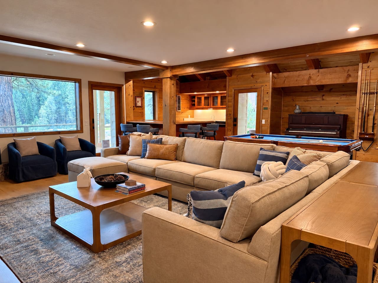 Large living room sectional adjacent to pool table, wet bar, dining table