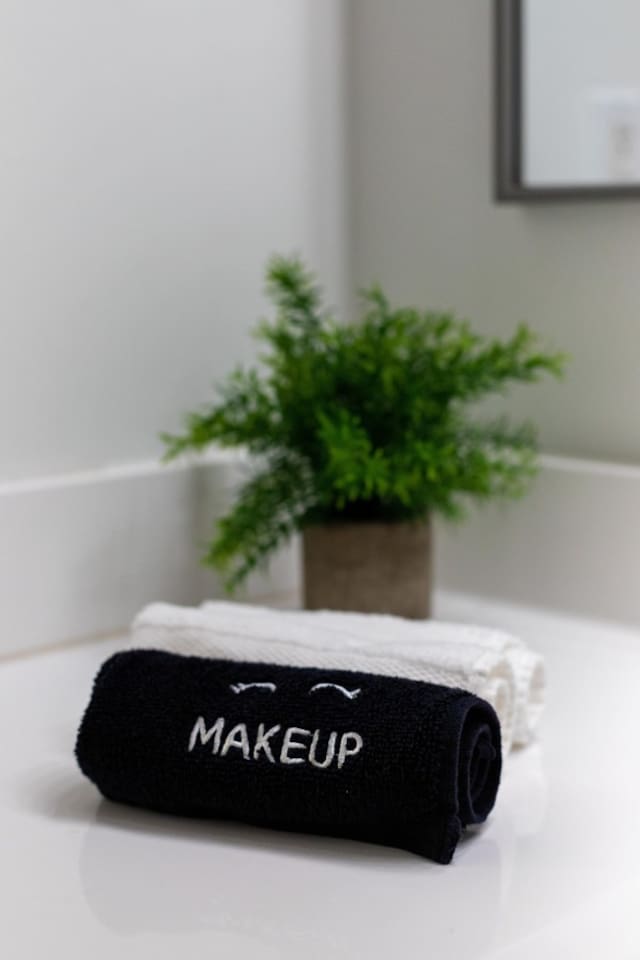 Experience our serene bathroom with plush towels and a touch of greenery.