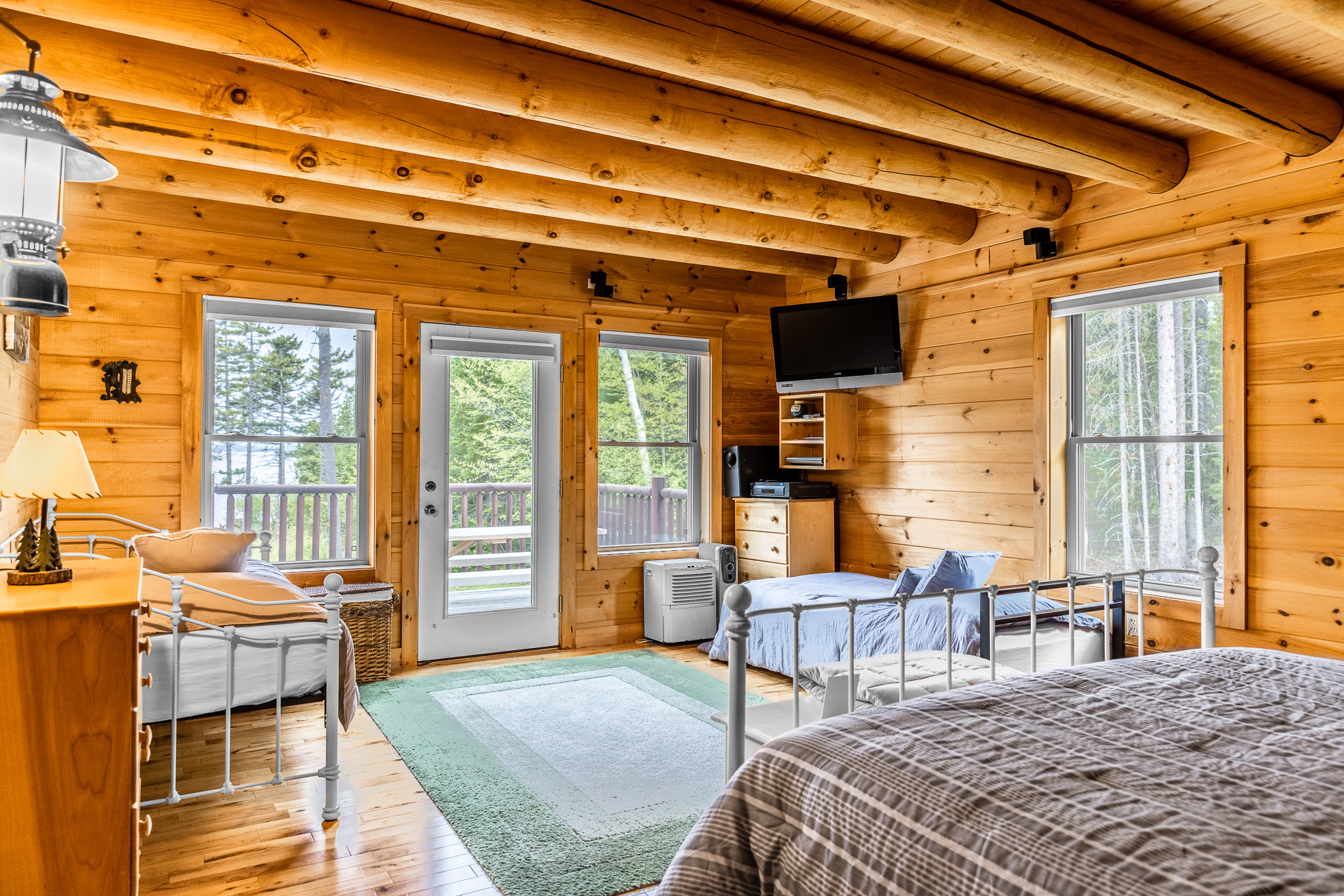The main floor master ensuite, with a comfortable king size bed, 2 twin beds, TV for streaming your favorite shows, and a private bathroom. Plus deck access with hammock outside overlooking the lake!