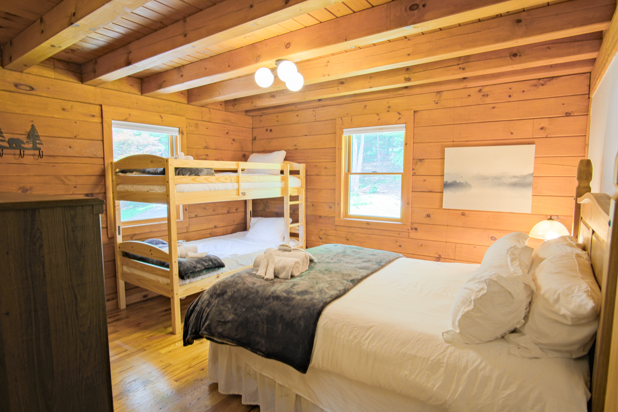 Offering a full size bed and a set of twin bunk beds, this second guest bedroom is perfect for a family, blending coziness and luxurious feel