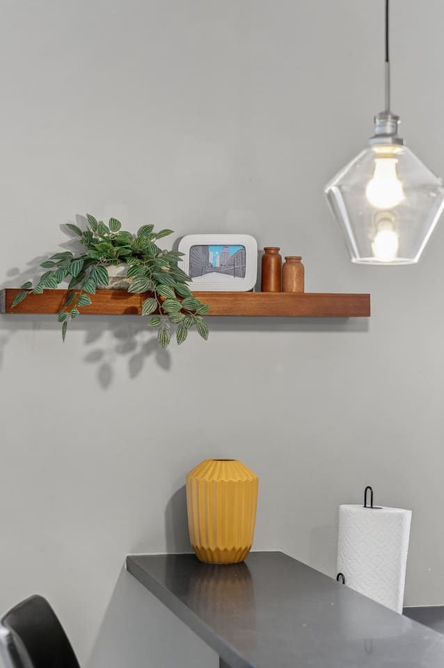 Modern design details with floating wood shelf, greenery, and chic décor accents. This stylish bar counter adds charm to the kitchen and dining area, blending function and contemporary style.