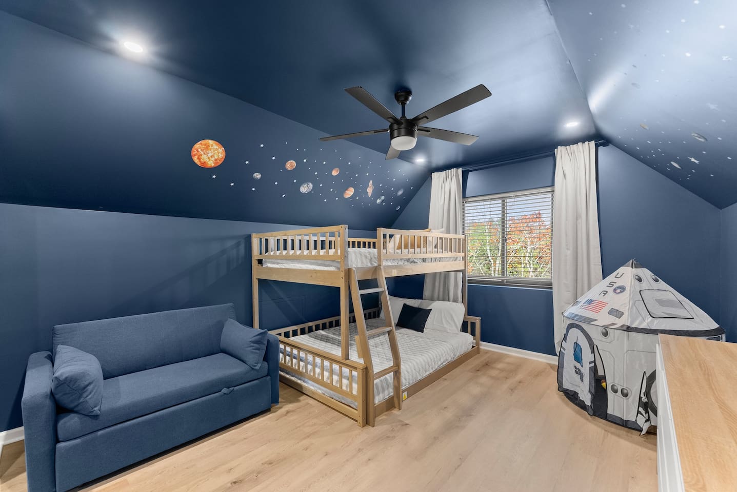 Fun, space-themed room painted in blue with a full-over-queen bunk bed and a sleeping chair—sleeps up to 4 guests.