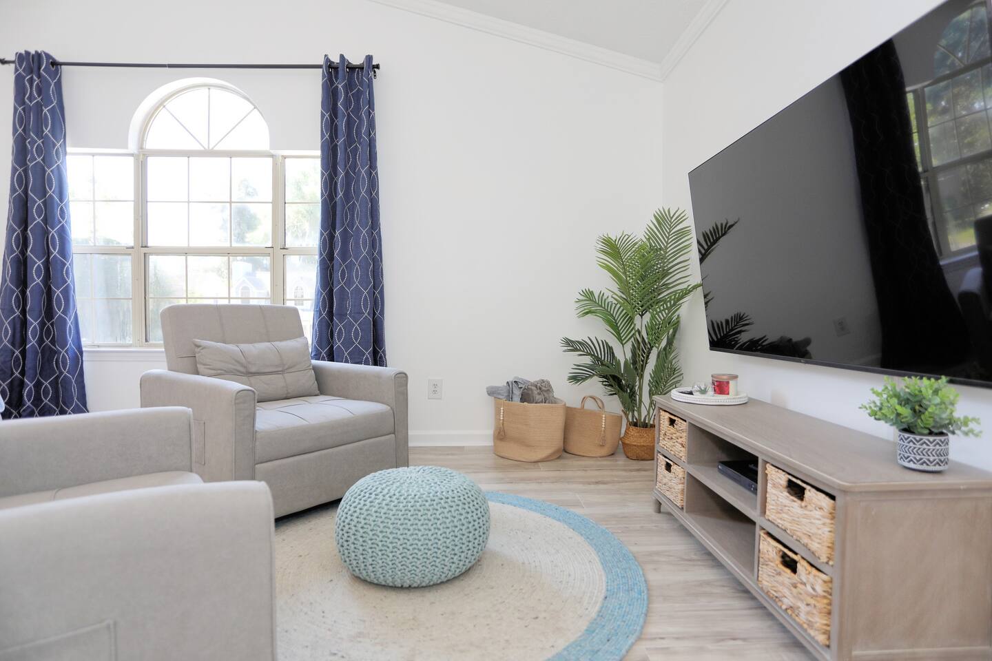 The primary bedroom at Pointe North Oasis is a relaxing retreat, complete with a luxurious king-sized bed, a smart TV for your entertainment, an ensuite bath for added privacy, and two cozy side chairs, perfect for unwinding after a day of exploring.