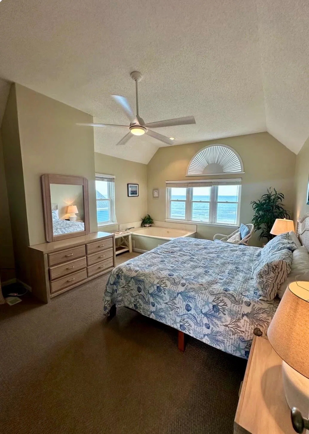 Primary bedroom with dresser and ocean-view windows