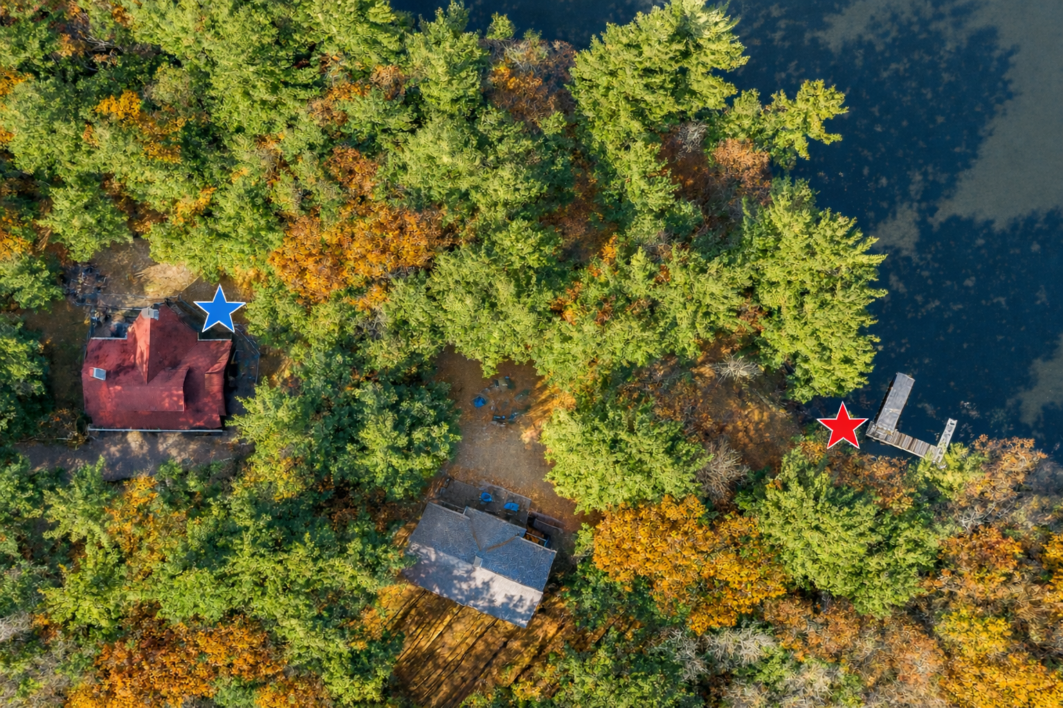 Aerial view of proximity to boat lift and access to Lake. Note the home is on the Lake but there is a short walk to access. Home is marked by a blue star and pier is marked by a red star.