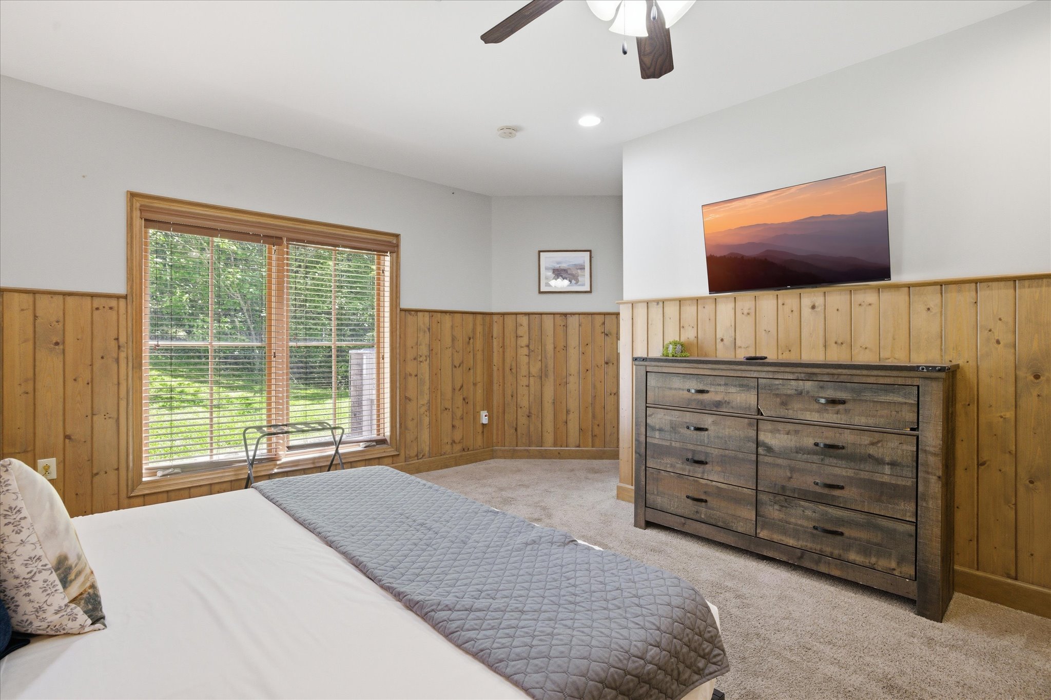 Wake up and step straight onto the porch from this roomy king bedroom in unit 312, complete with an ensuite bath, TV, and plenty of space to unpack and relax during your stay.