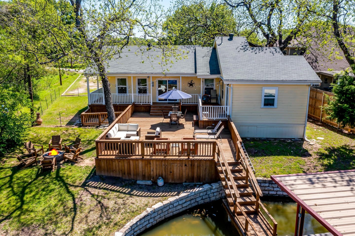 Oversized back deck with firepit and seating — perfect for sunset gatherings by the water.
