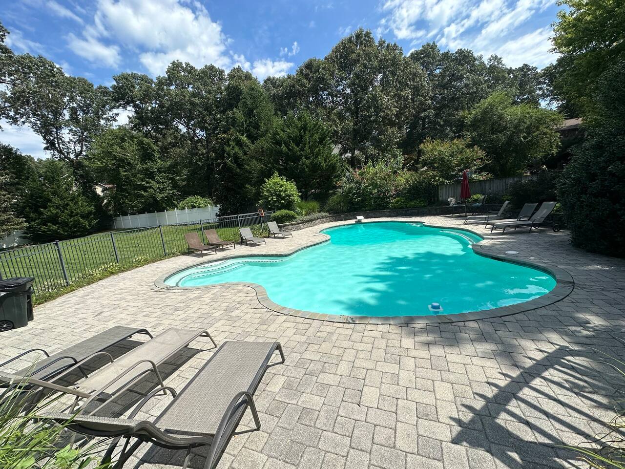 Pool has plenty of lounge chairs and is right next to back yard