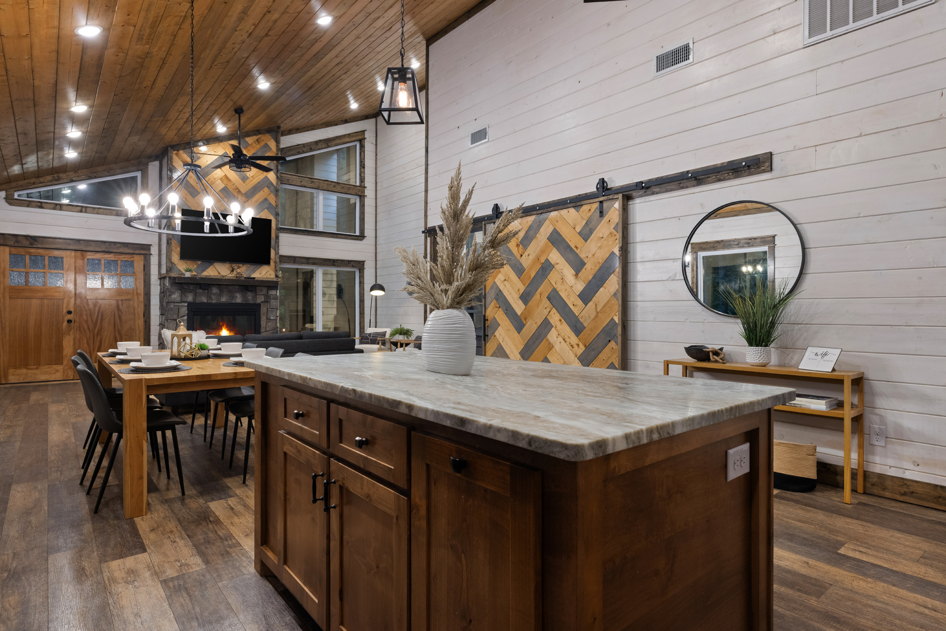 The heart of the cabin stays open to everything, so even the one cooking is still part of the conversation, the fireplace, and the fun.