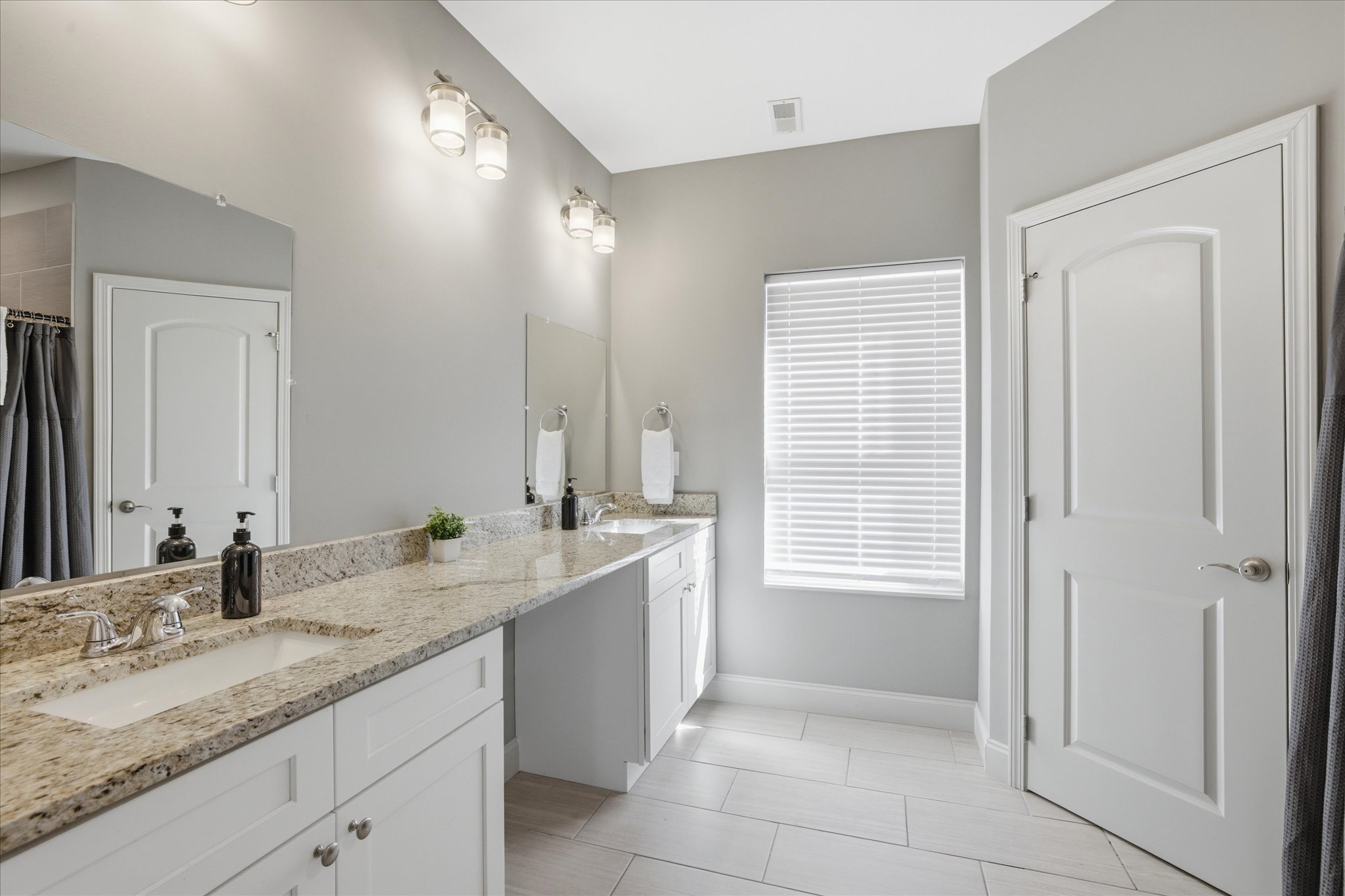 In Unit 1, this guest bathroom gives you room to actually get ready—double sinks, bright lighting, and enough space to spread out without bumping into each other. It keeps mornings smooth and evenings easy.