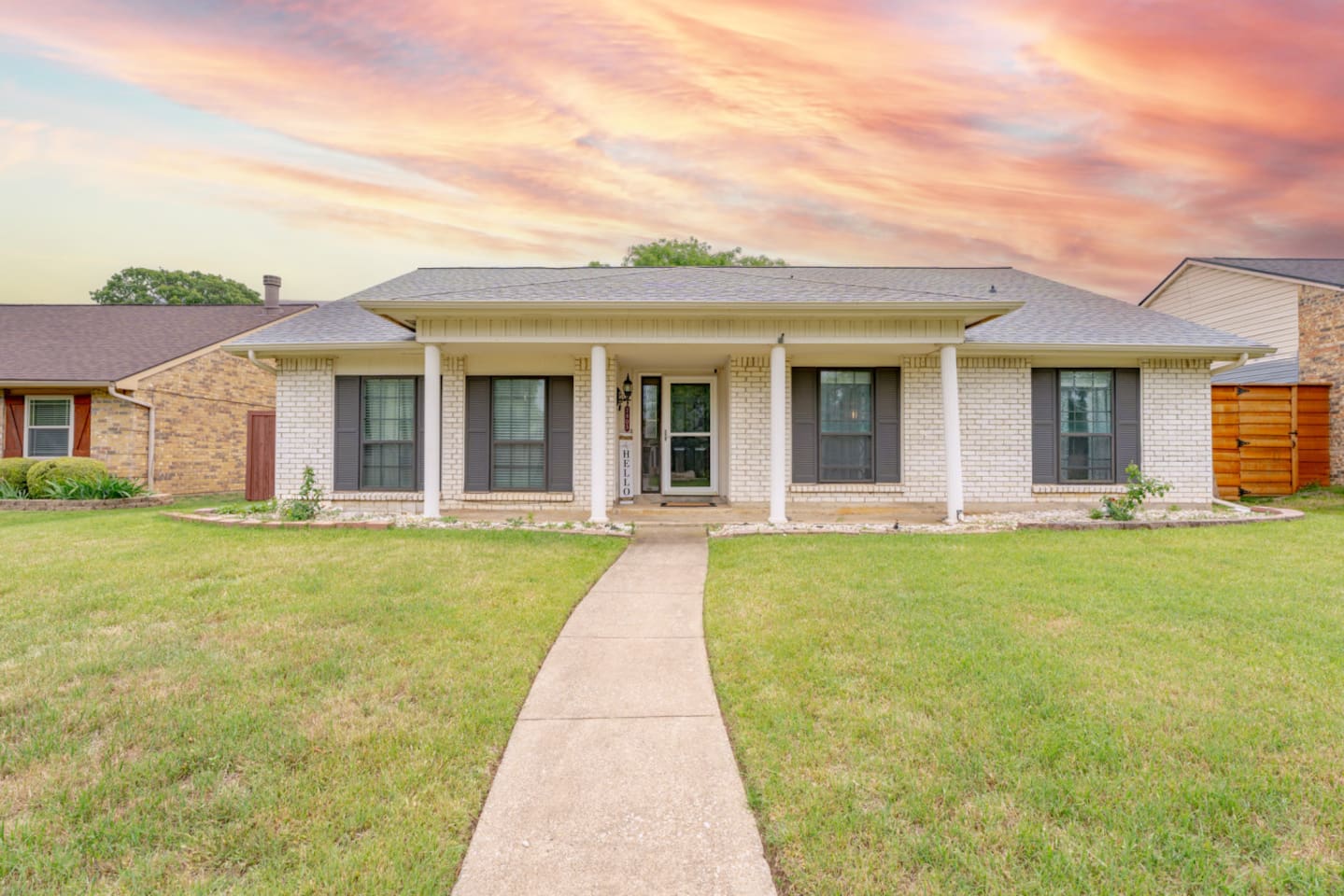 Welcoming curb appeal with manicured lawn and covered entry.
