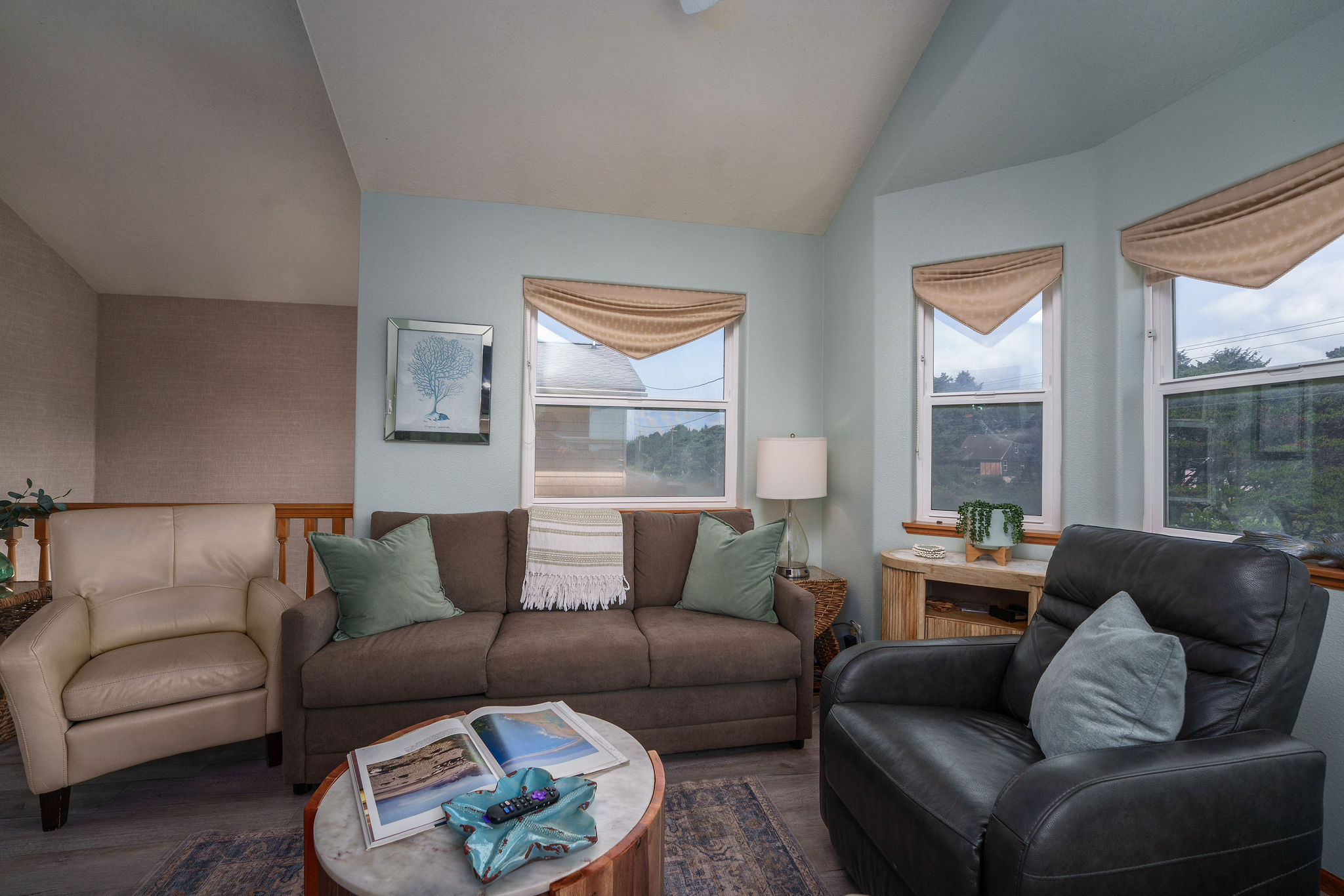 A well-lit, cozy living room interior with a queen sized pull-out sofa creates a comfortable area for the family to sit in.