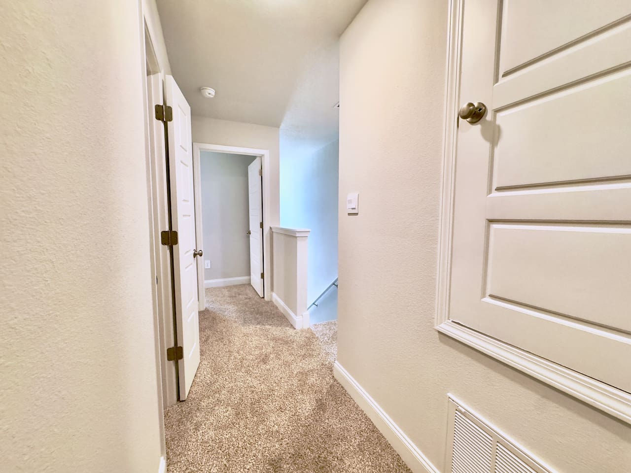 Quiet upstairs hallway, easy to move between rooms. Simple, tidy, effortless to navigate.