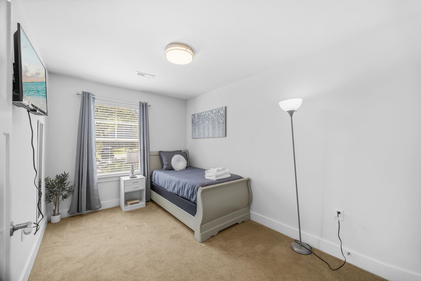 A cozy single bed with fresh linens, natural light, and calming décor makes this room ideal for relaxation.