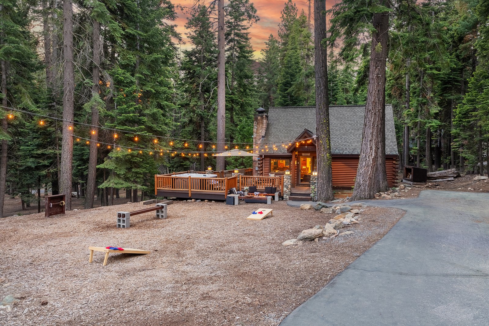 Park the cars and let the trip begin — string lights overhead, lawn games out front, and pines as far as you can see.
