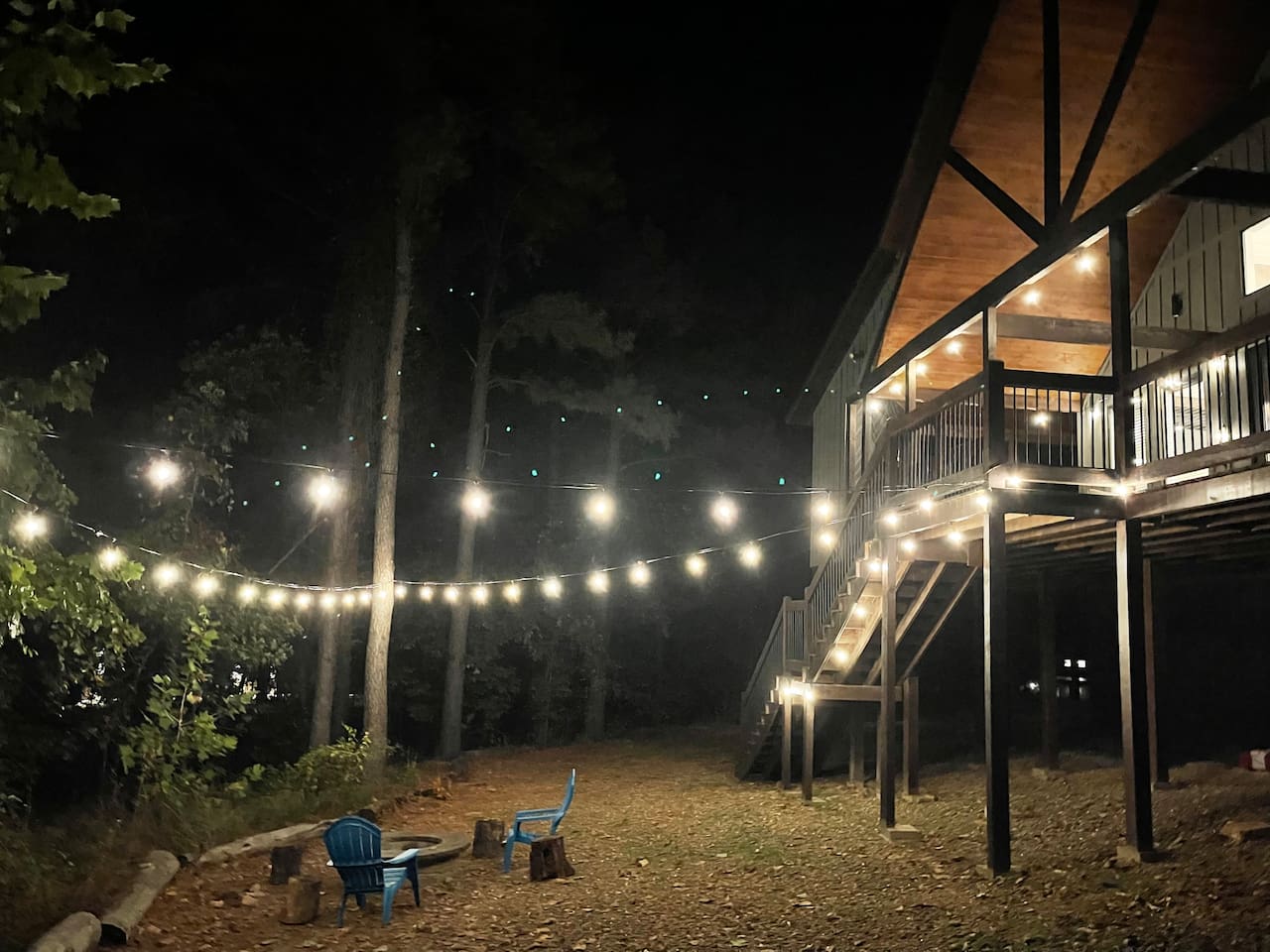 Overhead party lights provide subtle lighting for the back yard and fire pit area.