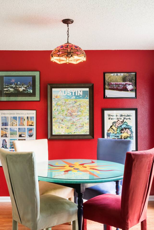 Gather around the hand-painted dining table in the bold, cherry-red dining space.