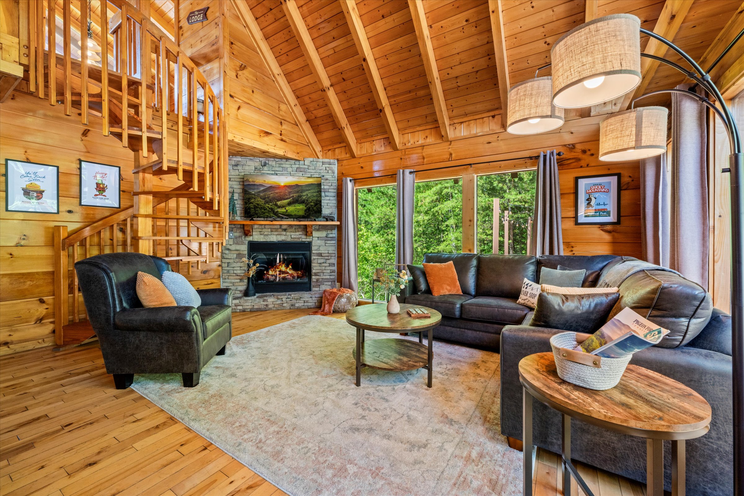 The heart of the cabin: cathedral ceilings, floor-to-ceiling windows, and a cozy gas fireplace for relaxing evenings.
