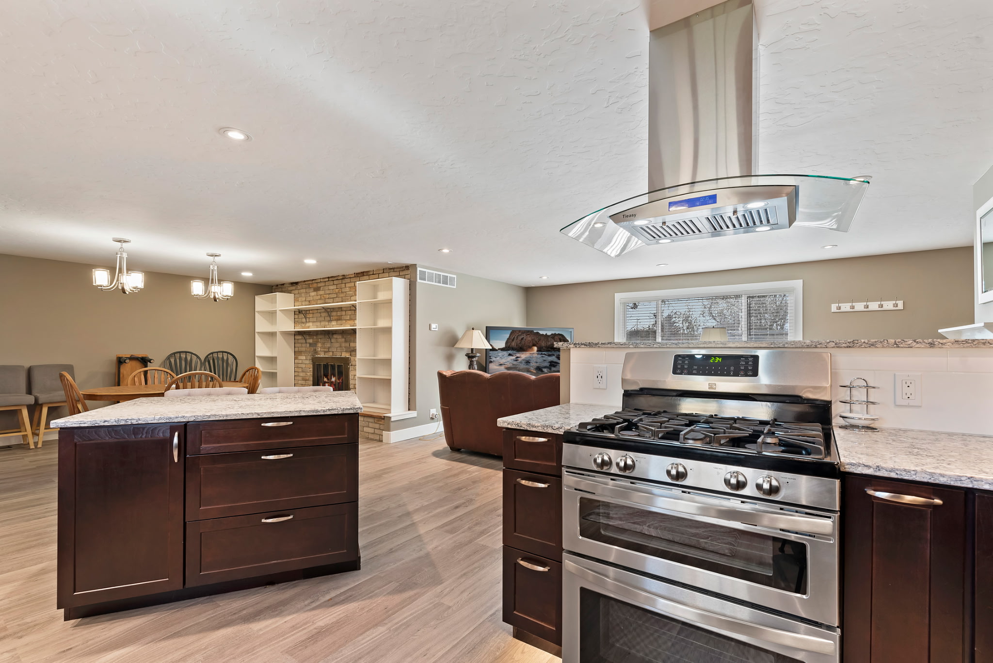 Well-appointed kitchen with a double oven range, overhead ventilation fan, and premium stainless steel appliances.