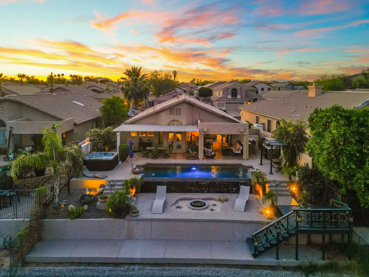 Your private backyard paradise, captured at golden hour — a sparkling pool with spa, covered patio, and fire pit create the perfect setting for evening cocktails and starlit conversations.