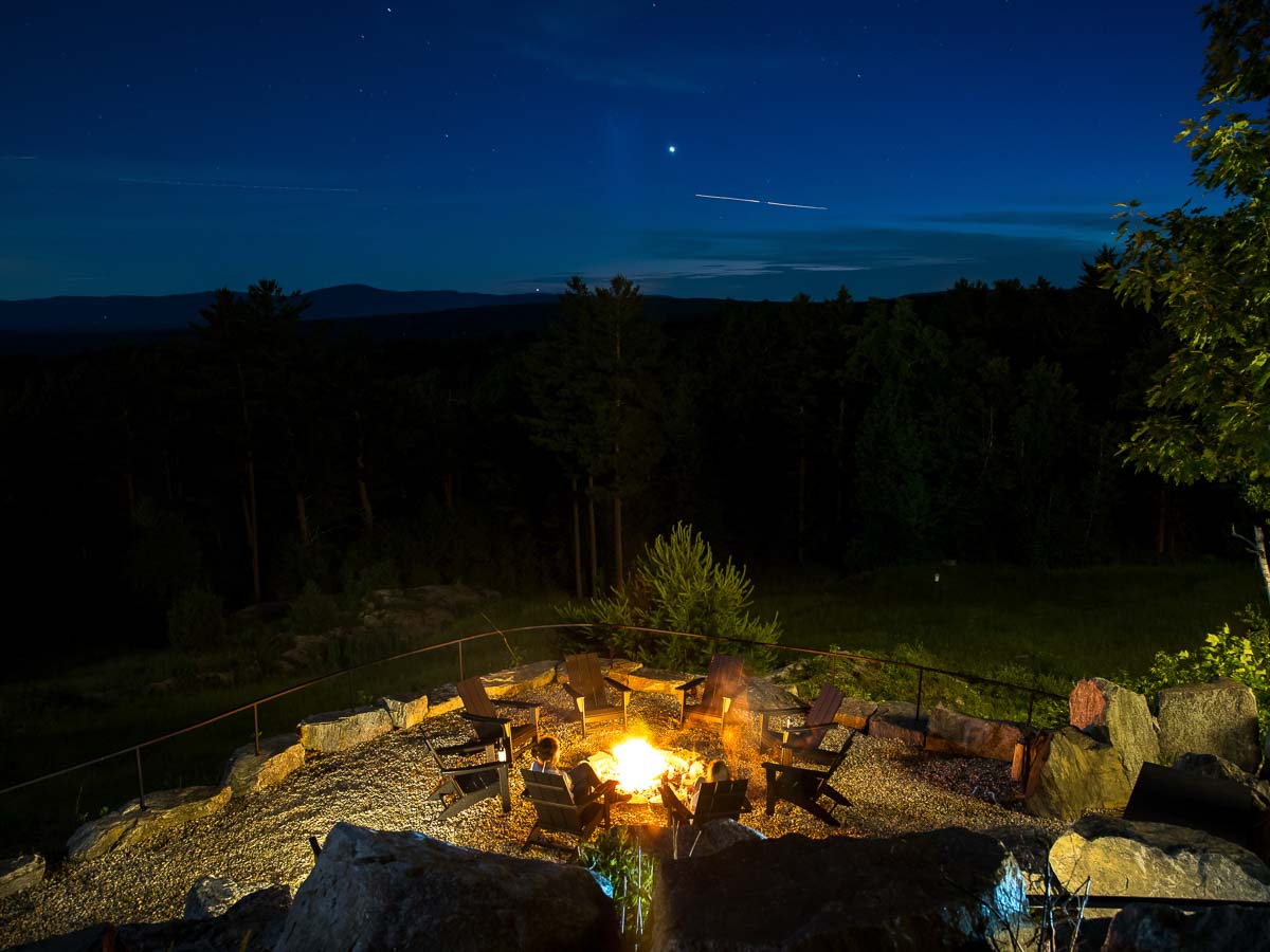 The tavern terrace fire pit lit at night, a shooting star above the Berkshires ridgeline &mdash; Sunset Falls