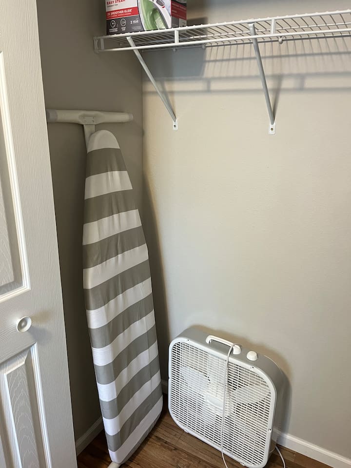 Ironing board, iron and fan. 