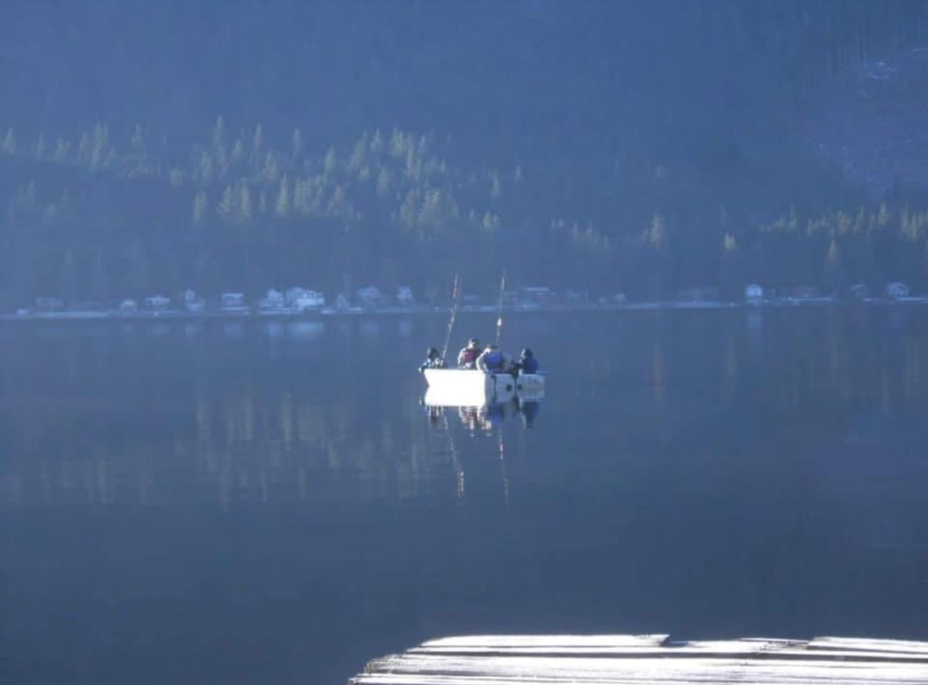 Calm lake with a fisherman in the distance.