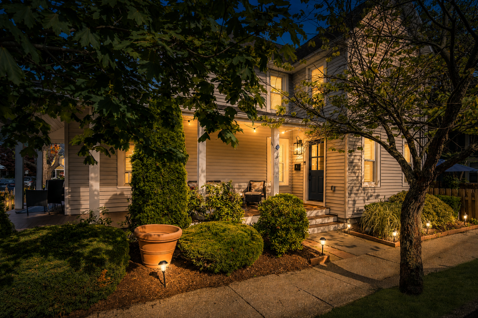 Come home to this every evening. The historic Victorian glows at blue hour, porch lights on, just a short stroll back from the beach and steps from Main Street.