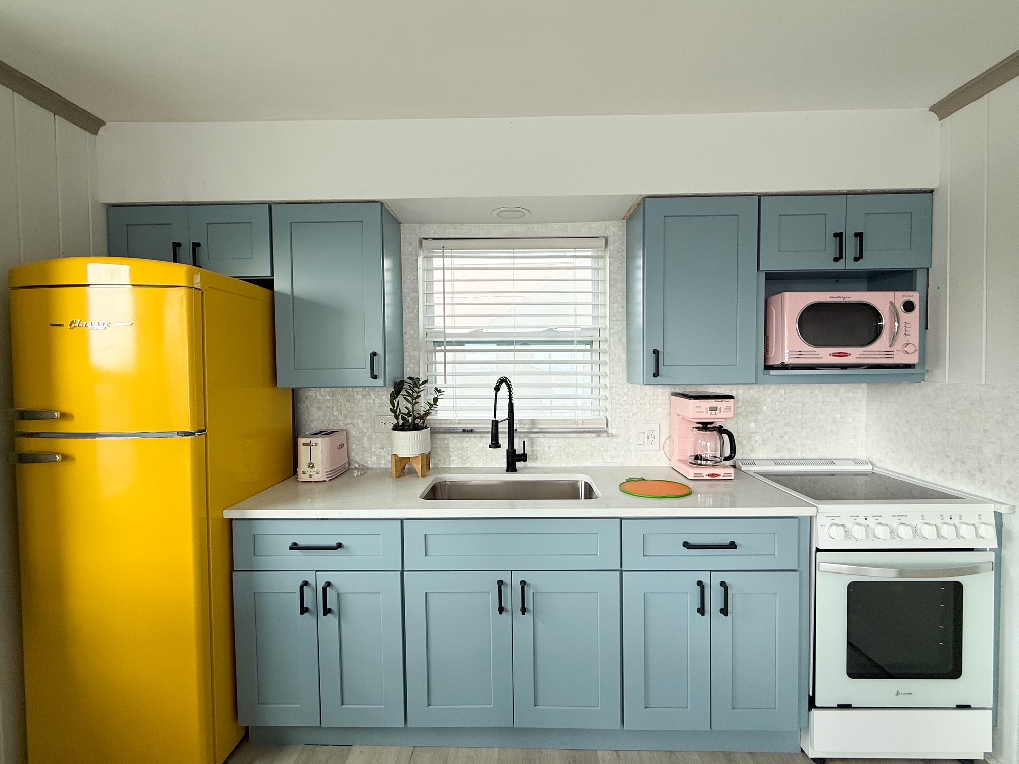 Retro Yellow Fridge, Pink Microwave, Pale Blue Kitchen Cabinets