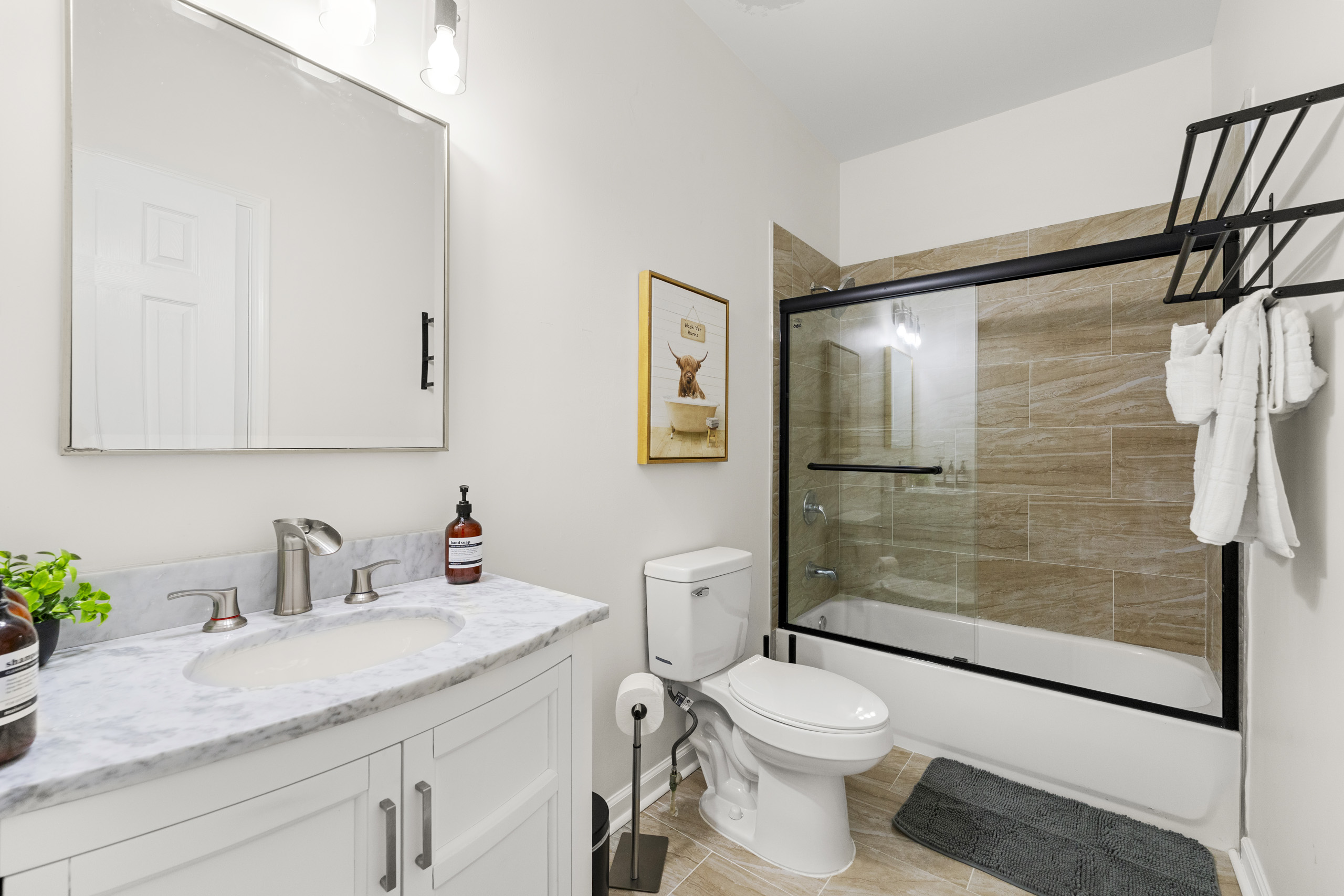 Freshen up in this modern bathroom with a deep tub and elegant finishes.