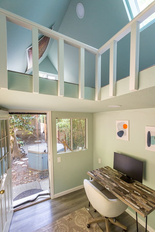 - Bright workspace with rustic desk, modern chair, and wall art
- Sliding door opens to garden views for inspiration and fresh air
- Loft area above adds a unique architectural touch to the space