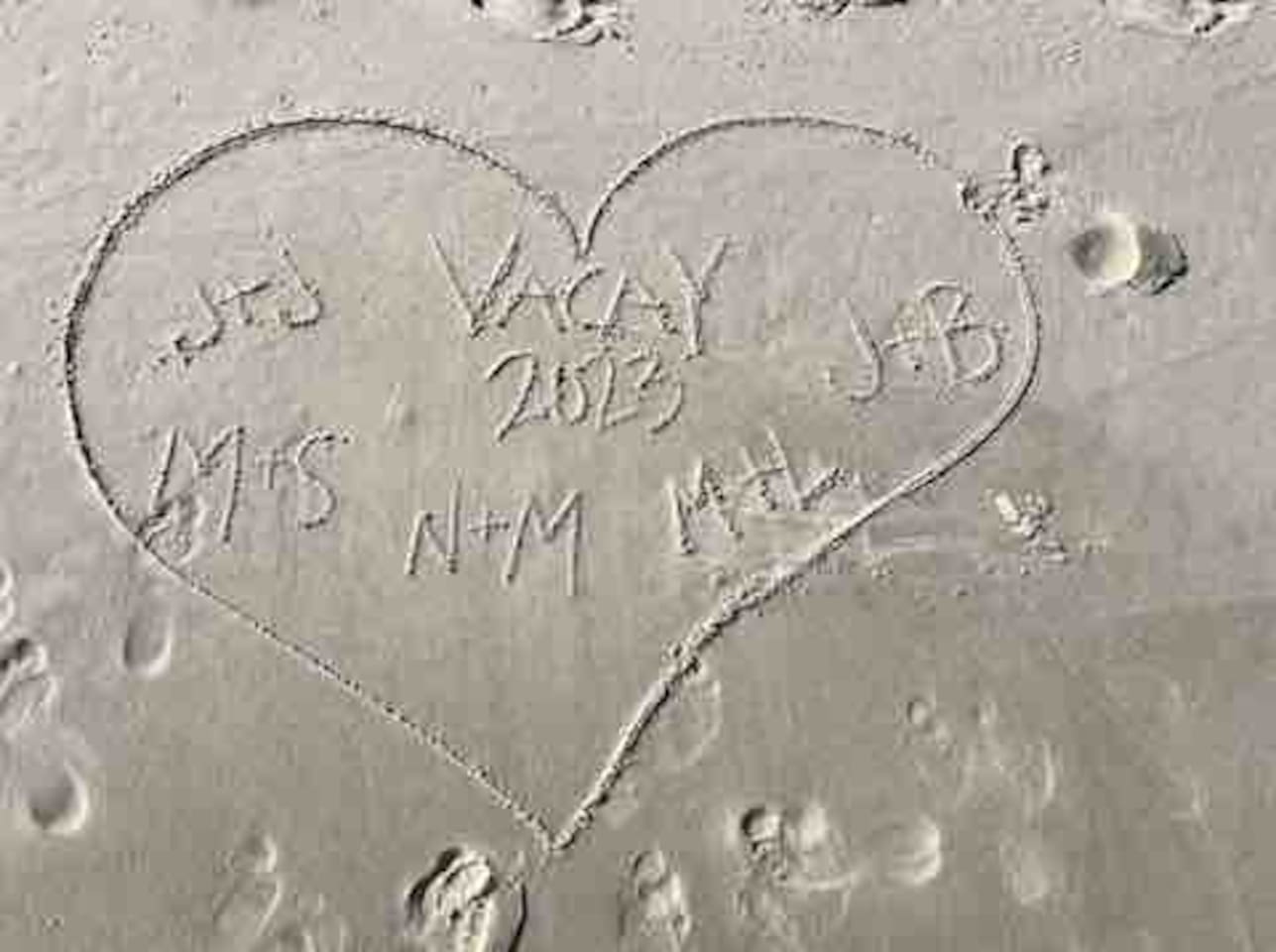  Beach vibes: Heart in sand marking 2023 love, memories, and connections.