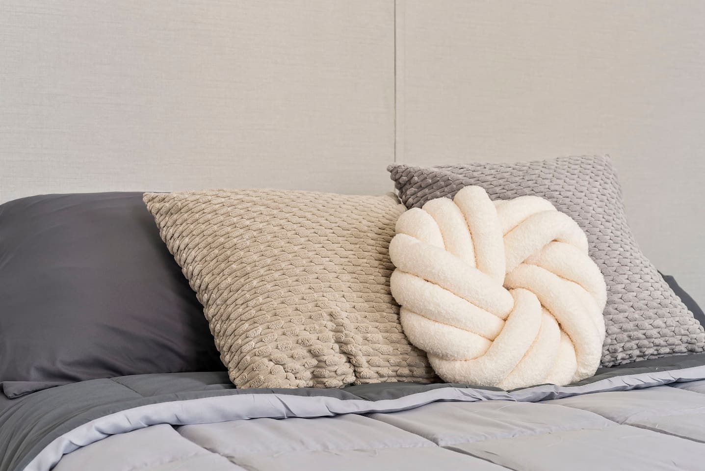 Another angle of the bed highlighting the layered pillows and comfortable sleeping setup.