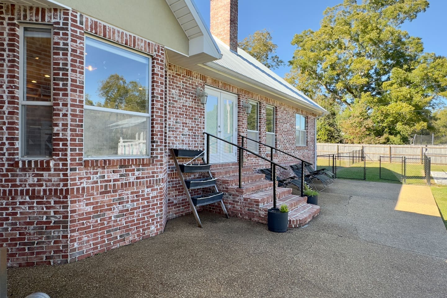 Red brick façade with a white roof and multiple windows creates timeless curb appeal.