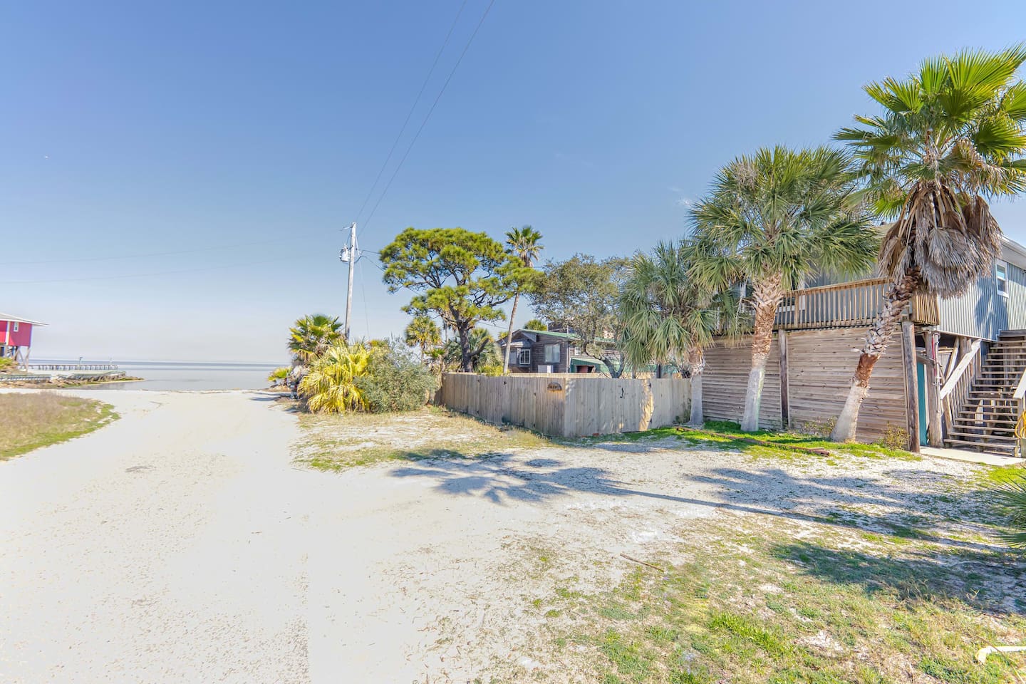 Exterior Paradise: Tropical palms greet you as you stroll to the serene Fort Morgan just steps away!